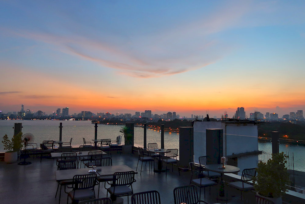 The golden hour at SkyOn9 creates magical moments for diners overlooking West Lake's tranquil waters 